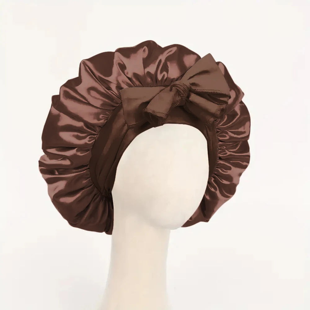 Brown satin bonnet with a bow on a mannequin head against a white background